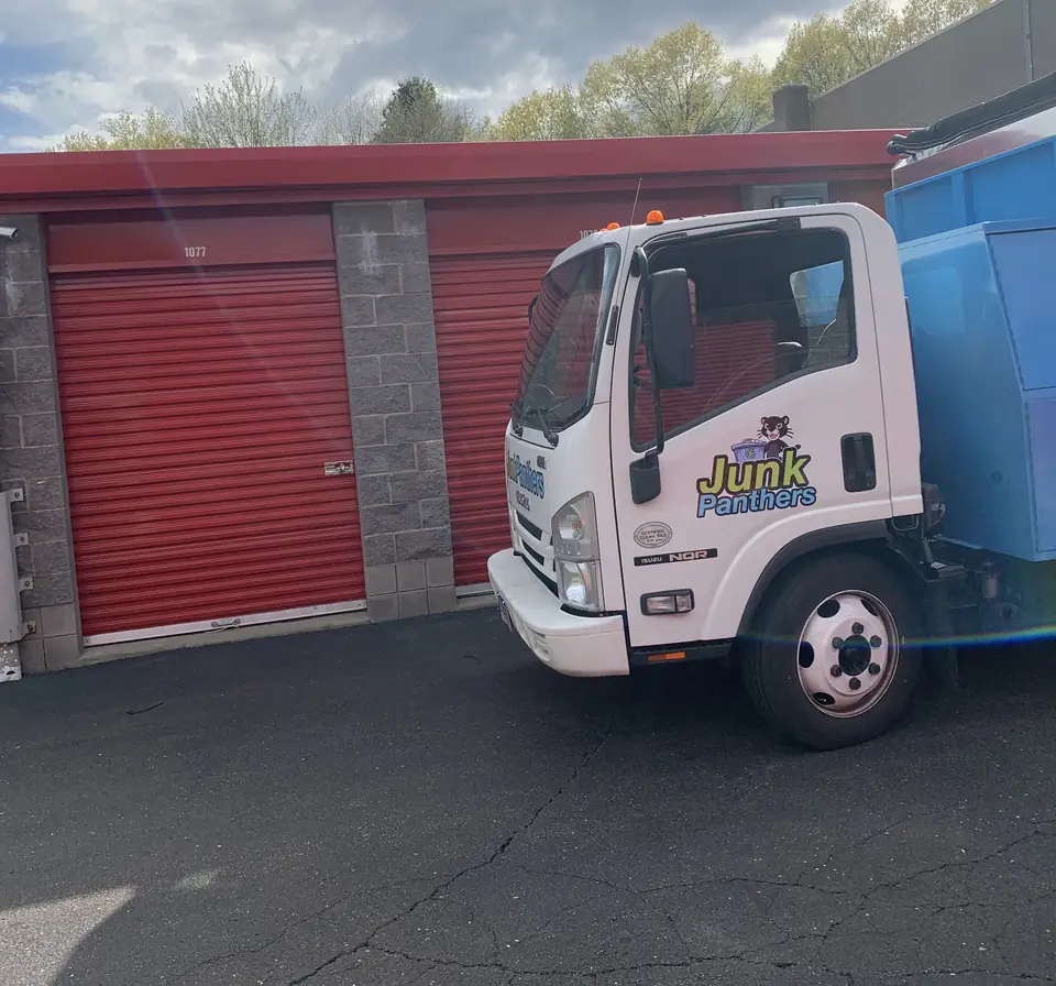 Junk Panthers truck parked in front of red storage unit doors